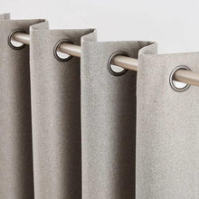 Gray curtain panels with round grommet holes for hanging on a curtain rod