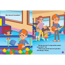 Hardcover storybook open spread with Blippi and children playing with blocks and toys