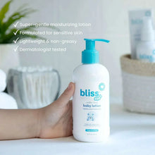 Baby lotion bottle with blue pump held in hand, front label visible