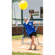Blue plastic baseball bat held overhead with yellow ball above the tee