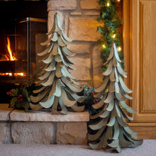 Metal cedar tree garden accents on stone hearth, teal-blue and gray layered branches