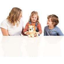 Talking Bingo plush held by children, orange and cream dog stuffed toy