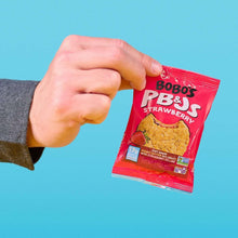 Bobo's PB&J strawberry oat snack packet held in a hand