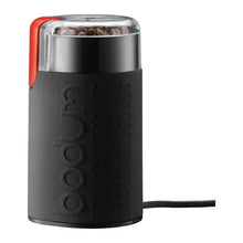 Black electric coffee grinder with stainless top, textured grip, red switch and power cord
