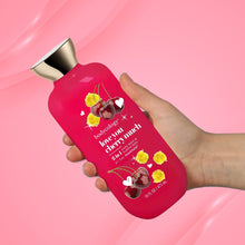 Red bodycology body wash bottle in hand with silver cap and cherry hearts label