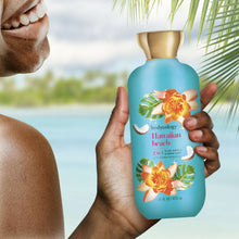 Turquoise body wash bottle held in hand with Hawaiian flower label