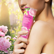 Bodycology pink vanilla wish body cream tube held near shoulder