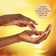 Hands lathering creamy white body lotion