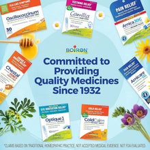 Assorted Boiron homeopathic medicine boxes on a blue surface with flowers