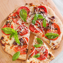 Sweet basil leaves on a tomato and cheese pizza, fresh garnish