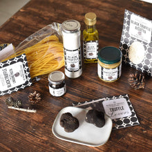 Black truffle pantry set items on tray: linguine pasta, jars, oil, sauce, and truffles
