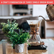 Glass pour-over coffee dripper with dark coffee and carafe
