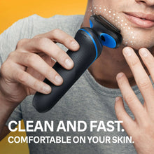 Electric shaver held to chin and cheek, blue accents on textured handle
