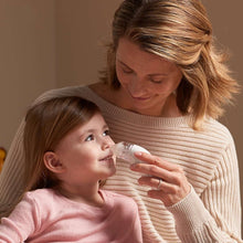 Parent holding a clear-tipped nasal aspirator near a child’s nose
