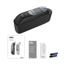 Black ear thermometer with display window and charging stand, plus included battery pack