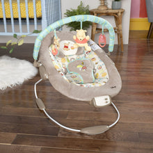 Baby bouncer with padded seat, hanging toys, and white vibration control unit