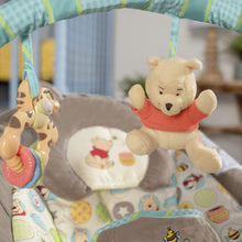 Baby bouncer seat with Winnie the Pooh and bee-themed plush hanging toys