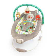 Gray baby bouncer seat with Winnie the Pooh cushion and hanging activity toys