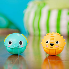 Two rolling animal ball toys on the floor: teal elephant and yellow lion