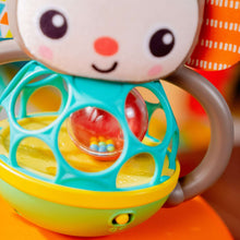Close-up of plush monkey face and teal ball cage with colored balls inside