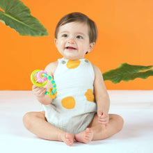 Baby holding turquoise and lime grab-and-spin rattle with clear spinning ball drum