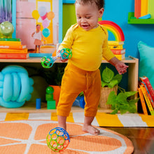 Baby playing with a colorful ring rattle ball with transparent bead chamber