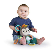 Baby holding sloth take-along activity toy with colorful rings and fabric links