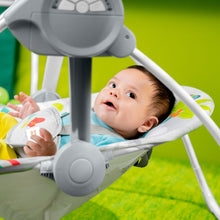 Baby in a portable swing with hanging toy bar and gray base