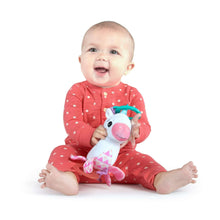 Unicorn plush clip-on toy held by baby in red outfit, teal handle visible