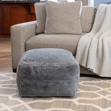 Dark gray faux fur pouf with rounded square shape and plush texture