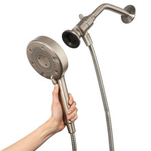 Handheld shower head held in hand with flexible metal hose and round nozzle face