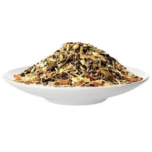 Loose leaf tea in white bowl, golden green dried leaves and buds