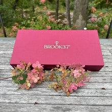 Loose leaf tea giftbox, pink lid with BROOK37 logo, shown closed on table