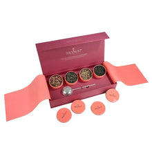 Loose leaf tea giftbox with four tins, several orange tin lids, and tea scoop inside
