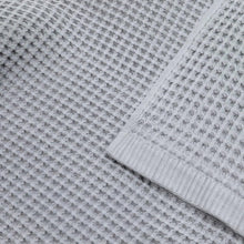 Gray waffle bath towels, close view of folded edge and looped texture
