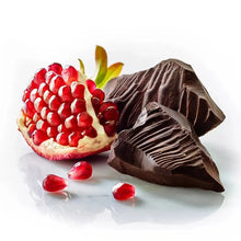 Pomegranate chocolate pieces and dark chocolate cone-shaped bites on a plate