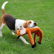 Fox rope dog toy with orange body and black feet held by a beagle on grass