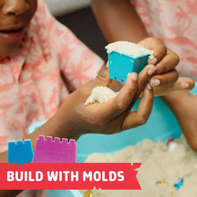 Child hands using a blue sand mold while playing in a sensory treasure bin
