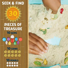 Child hands digging in sand in a blue treasure hunt sensory bin with gems and coins