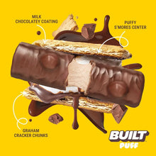 Protein bar with milk chocolate coating, graham cracker chunks, and puffy center