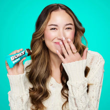 Wrapped Built Puff protein bar held near face with hand visible