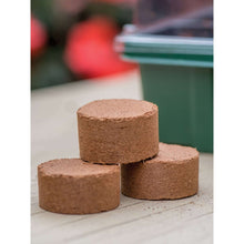 Compressed seed-starting pellets, brown coconut-fiber disks, three stacked