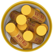 Bowl of yellow lip balm sticks with branded caps