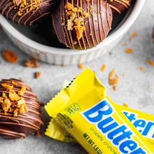 Butterfinger candy bar pieces with chocolate drizzle and yellow wrappers