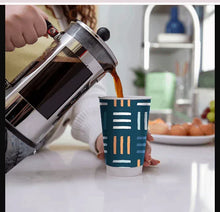 Chinet Comfort insulated cup with teal pattern, being filled with coffee
