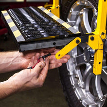 CAT tire service step showing black platform with traction strip and mounting hardware