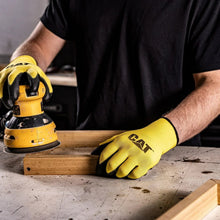 Yellow and black work glove on hand, black grip palm with CAT logo