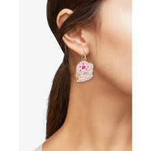 Heart cake earrings with pearl beads and pink-red center, worn on ear