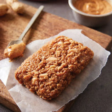 Brown energy bar with crunchy topping on parchment paper