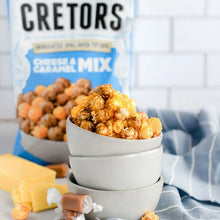 Cheese and caramel popcorn mix bag beside bowl of popcorn and cheese pieces